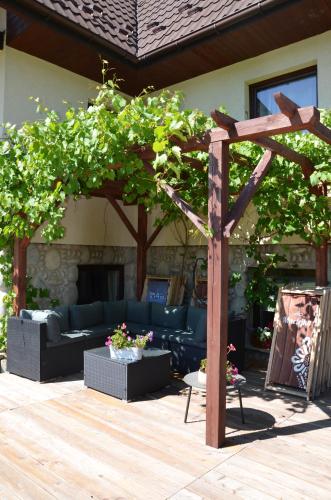 a wooden pergola with couches and a fireplace at Willa Maciejka in Trybsz