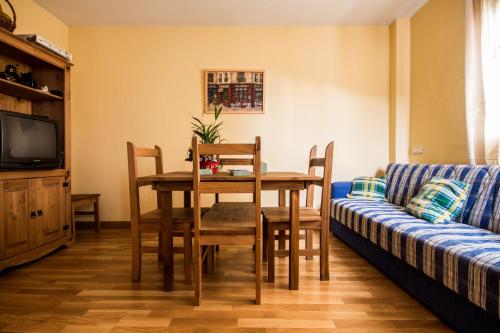 a dining room with a table and a couch at Hotel Rural El Paraiso de Gredos in Cuevas del Valle