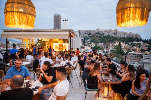 a crowd of people sitting at tables at a restaurant at Ciel Living Athens in Athens
