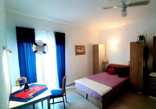 - une chambre avec un lit, un bureau et une fenêtre dans l'établissement Apartments Luxor, à Rogoznica