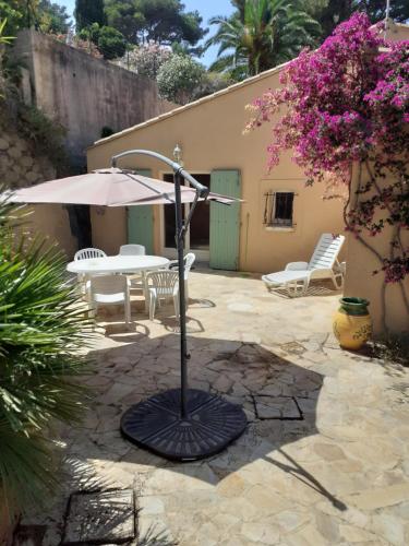 un patio avec une table et un parasol dans l'établissement tres beau T1, à Hyères