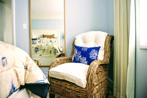 a wicker chair in a room with a mirror at Villa Venezia in Fort Lauderdale