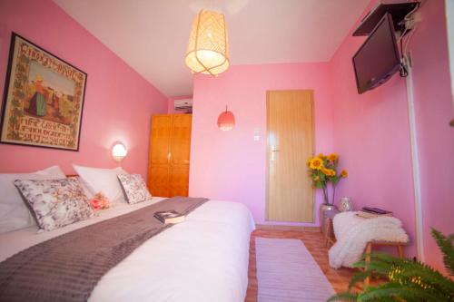 1 dormitorio con 1 cama grande y paredes de color rosa en Roso, en Gradac