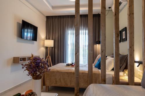 a bedroom with a bed and a large window at Mageiras Boutique Hotel in Afitos