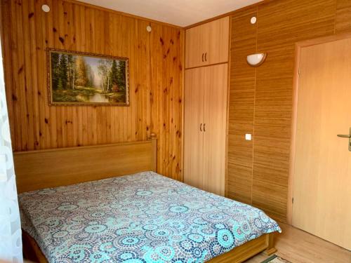 a bedroom with a bed in a wood paneled room at Комфортабельный коттедж in Svityazʼ