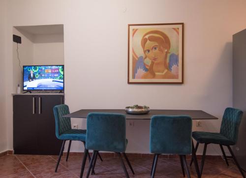 een eettafel met stoelen en een schilderij aan de muur bij Apartmani Stones Sutivan I in Sutivan