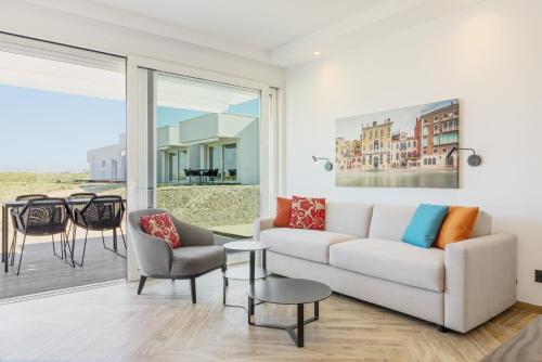 a living room with a couch and a table and chairs at Hapimag Apartments Cavallino in Cavallino-Treporti