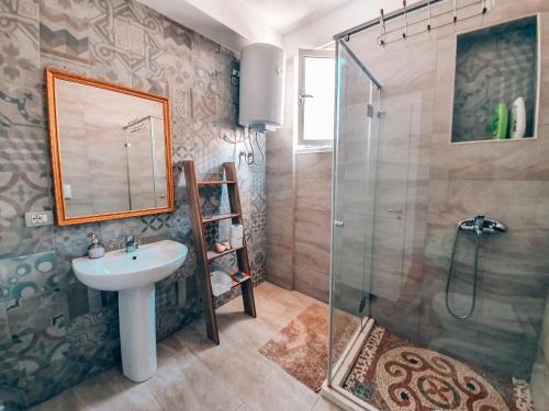 ヴロラにあるAqua Holiday Apartmentsの洗面台とシャワー付きのバスルーム