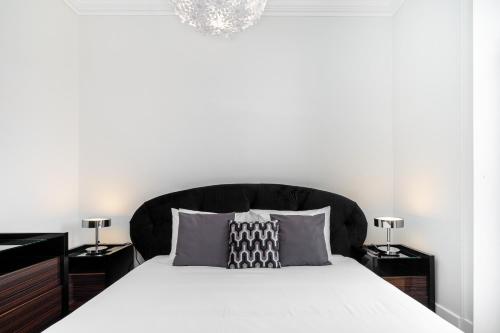 Schlafzimmer mit einem großen Bett mit einem schwarzen Kopfteil in der Unterkunft WHome | Prime Location Design Family Apartment in Lissabon