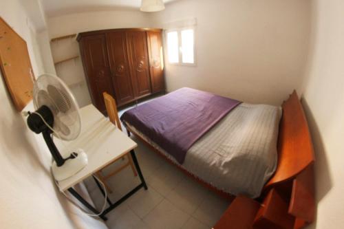 瓦倫西亞的住宿－apartemento ideal familia y grupo climatisacion playa poblaA，一间小卧室,配有一张床和一张带风扇的书桌