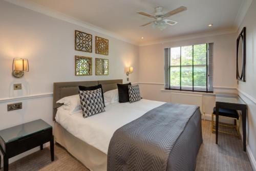 a bedroom with a bed and a ceiling fan at Collingham Serviced Apartments in London