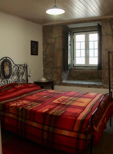 a bedroom with a large bed and a window at Casa do Balcão in Alcains