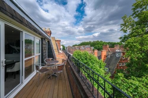 a balcony with a table and chairs on a building at Collingham Serviced Apartments in London