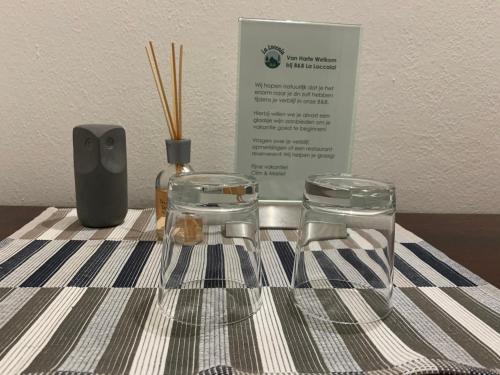 a table with two clear chairs and a bottle and a sign at B&B La Loccaia in Ciggiano