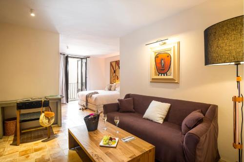 a living room with a couch and a bed at Hotel La Torre del Canonigo - Small Luxury Hotels in Ibiza Town