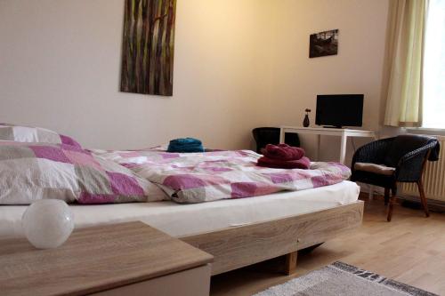 - une chambre avec un lit, un bureau et une télévision dans l'établissement Ferienwohnung Kutschenmeyer, à Schneverdingen