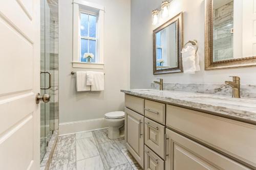 uma casa de banho com um WC, um lavatório e um espelho. em Hosteeva Private Condo w Pool and High-end amenities Near Frnch Quarter em Nova Orleans