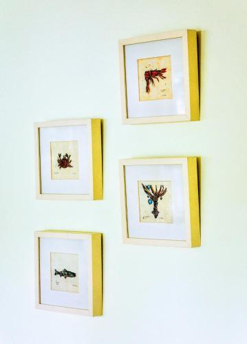 a group of framed pictures on a white wall at Villa Venezia in Fort Lauderdale