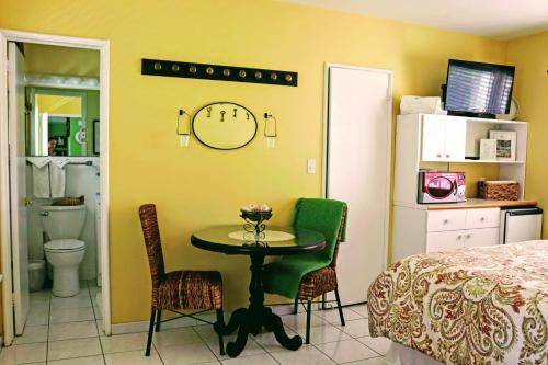 a bedroom with a table and a bed and a clock on the wall at Villa Venezia in Fort Lauderdale