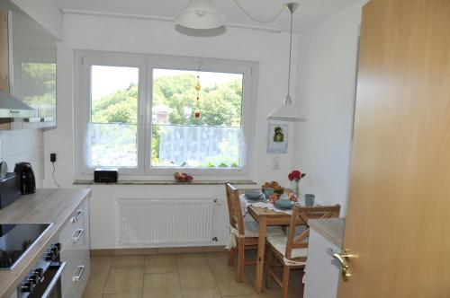 a kitchen with a dining table and a window at Rothaarsteig Ferienhaus in Kirchhundem