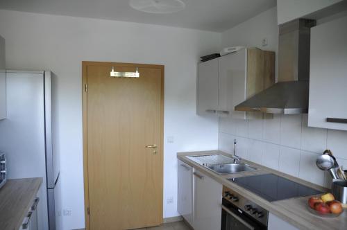 a kitchen with a sink and a wooden door at Rothaarsteig Ferienhaus in Kirchhundem
