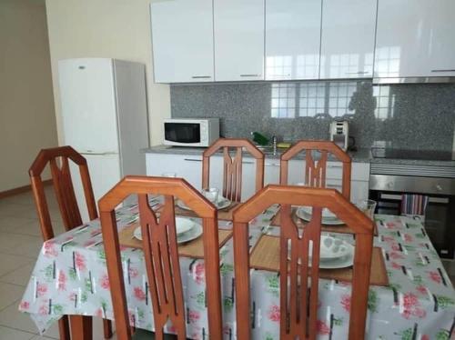une cuisine avec une table et trois chaises et une table dans l'établissement Casa do Cascão, à Louredo