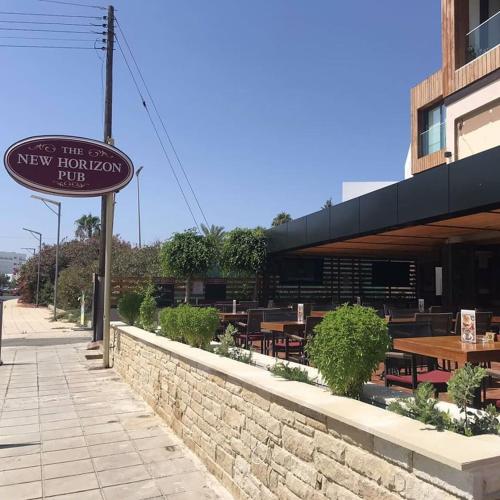 a sign for a new horizon restaurant with tables at Terrazza Suites in Paphos City