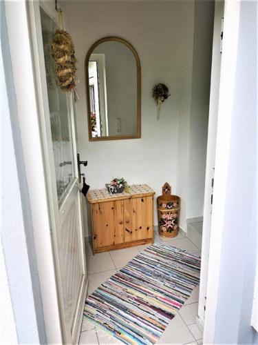 a hallway with a bathroom with a mirror and a rug at Ferienwohnung Gerti in Mauth