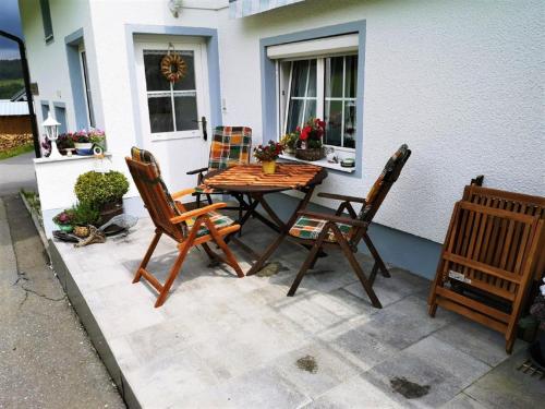 a wooden table and chairs sitting on a patio at Ferienwohnung Gerti in Mauth