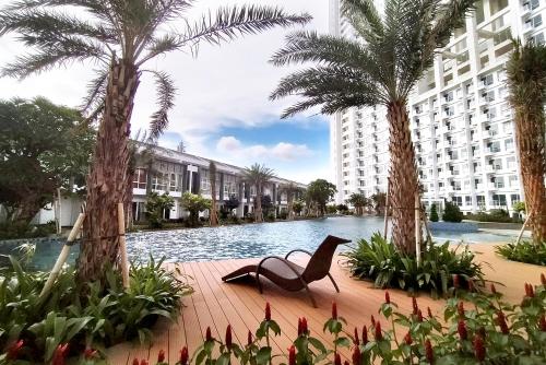 a chair sitting in the middle of a pool with palm trees at Harris Suites Puri Mansion in Jakarta