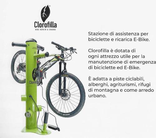 a bike on a green stand with a bike on it at Park Hotel Arnica in Falcade