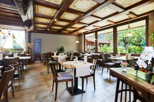 a restaurant with wooden ceilings and tables and chairs at Landhotel Kuralpe Kreuzhof in Lautertal