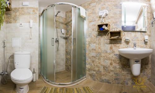 a bathroom with a shower and a toilet and a sink at Wellness Hotel Bulgaria in Bansko