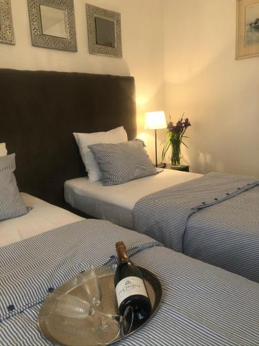 a bottle of wine sitting on top of two beds at Villa Magdalena in Kutná Hora