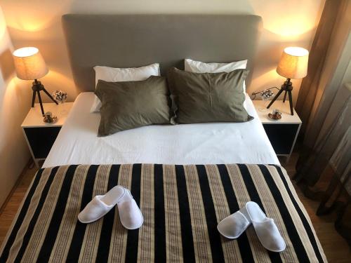 a bed with a pair of white shoes on it at Villa Magdalena in Kutná Hora