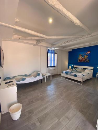 a room with two beds and a blue wall at La Conchiglia 2.0 in Soverato Marina