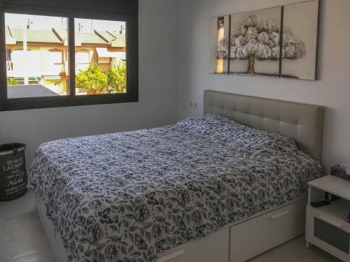 a bedroom with a bed with a black and white comforter at Entremares in Lo Pagán