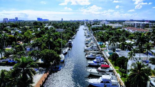 a group of boats docked in a canal with palm trees at Villa Venezia in Fort Lauderdale