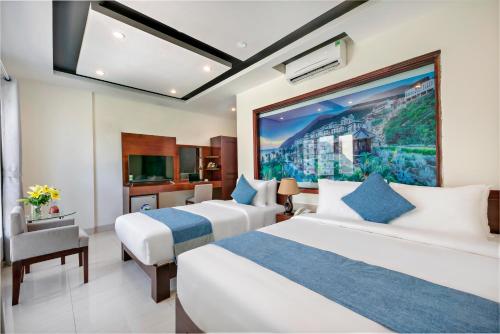 a hotel room with two beds and a tv at Gio Bien 2 Hotel by THG in Danang