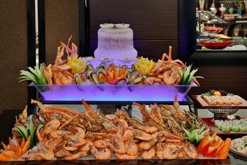 a buffet of food with shrimp and vegetables on a table at Voco - Riyadh by IHG in Riyadh