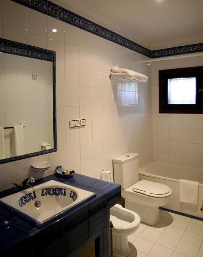a bathroom with a sink and a toilet and a tub at Casa Grande de Soutullo in Coles