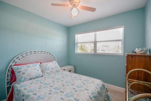 a bedroom with a bed with a ceiling fan at Charming Beachside Home by Ocean Properties in New Smyrna Beach