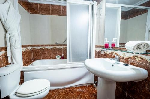 
a bathroom with a sink, toilet and bathtub at Hotel Gines in Ginés
