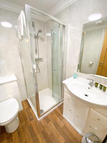 a bathroom with a shower and a toilet and a sink at Cairngorm Guest House in Aviemore