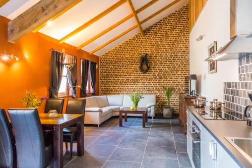 a kitchen and living room with a couch and a table at Valkenhof Schimmert in Schimmert