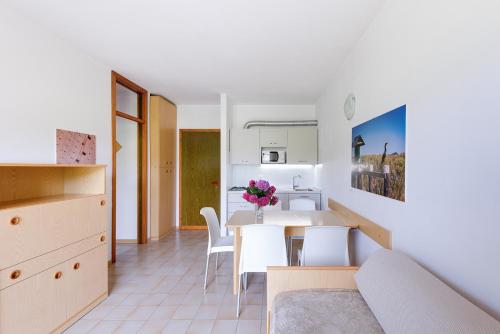 sala de estar y cocina con mesa y sillas en Condominio Lavinia, en Bibione