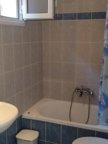 a bathroom with a tub and a toilet and a sink at Anestis Studios in Agios Georgios