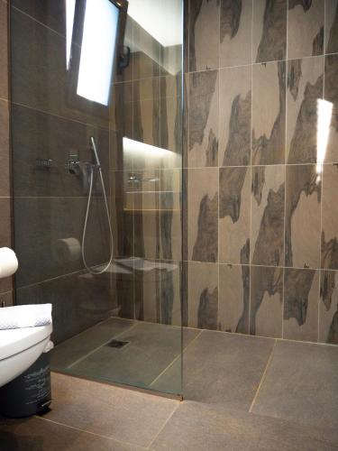 a bathroom with a glass shower with a toilet at Cypress Garden Villas in Svoronata