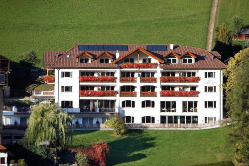 a white house with a blue roof and white walls at Hotel Grones in Ortisei