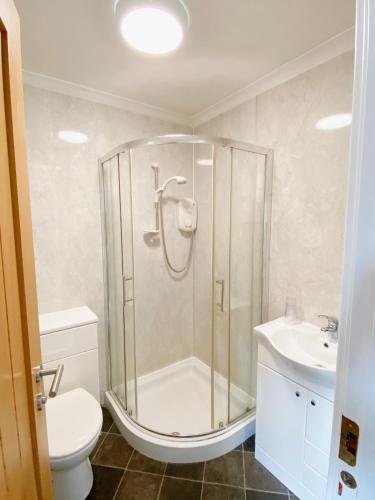 a bathroom with a shower and a toilet and a sink at Cairngorm Guest House in Aviemore